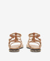 Pair of gold sandals with studded details on a white background rear view