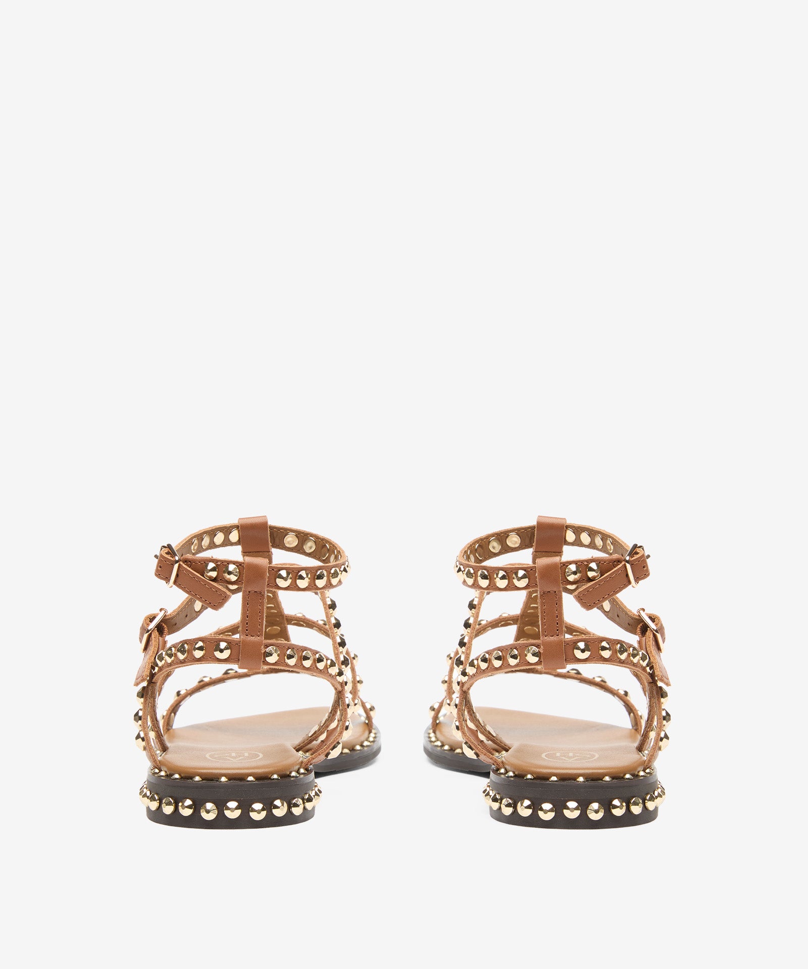 Pair of gold sandals with studded details on a white background rear view