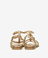 Gold sandal with gold studs on a white background rear view