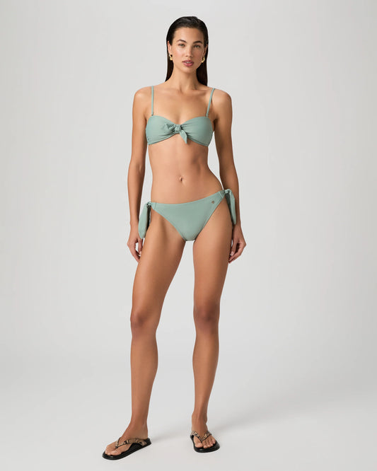 Woman wearing a green bikini from paige on a white background