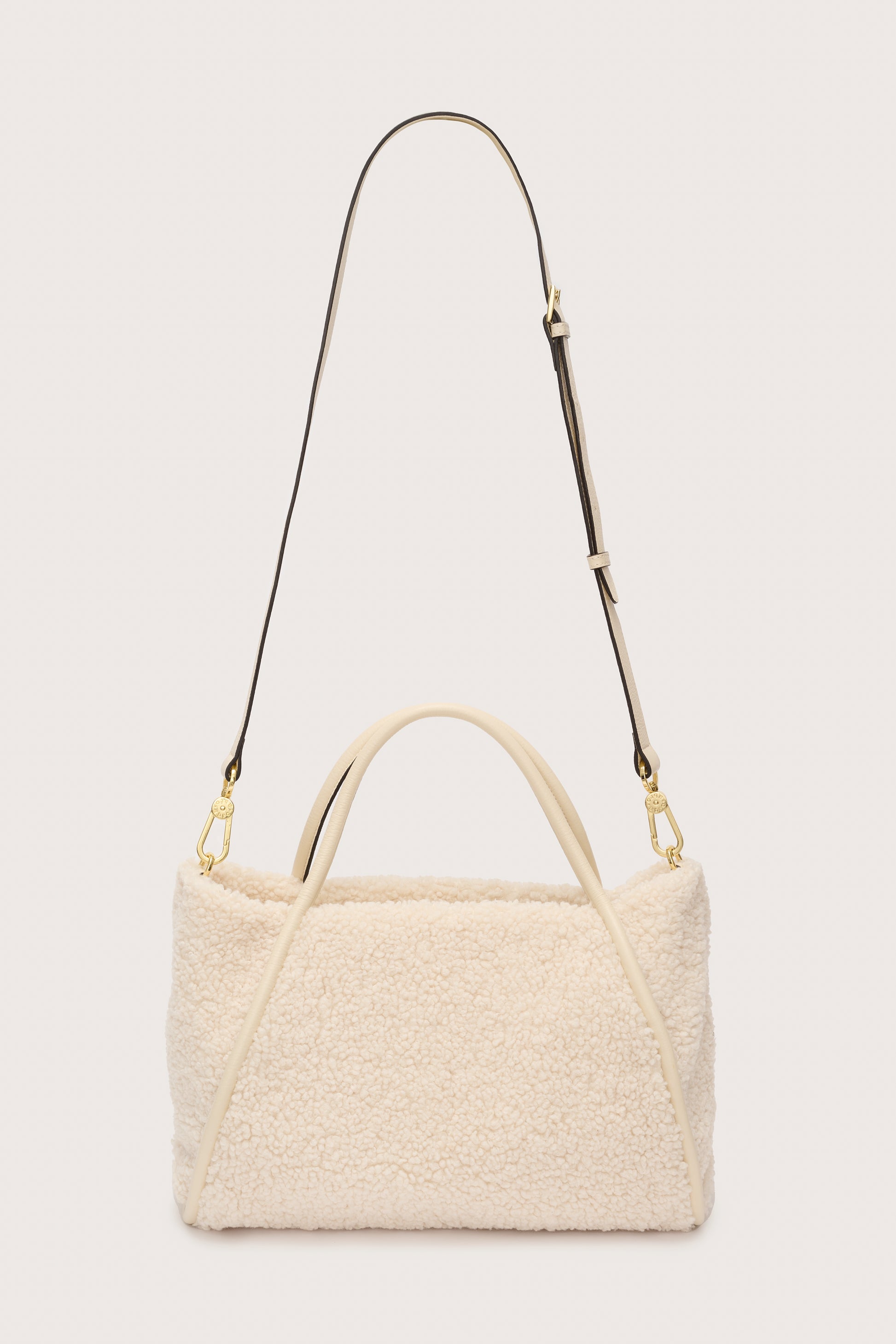 Reverse of cream faux fur bag with cross body strap