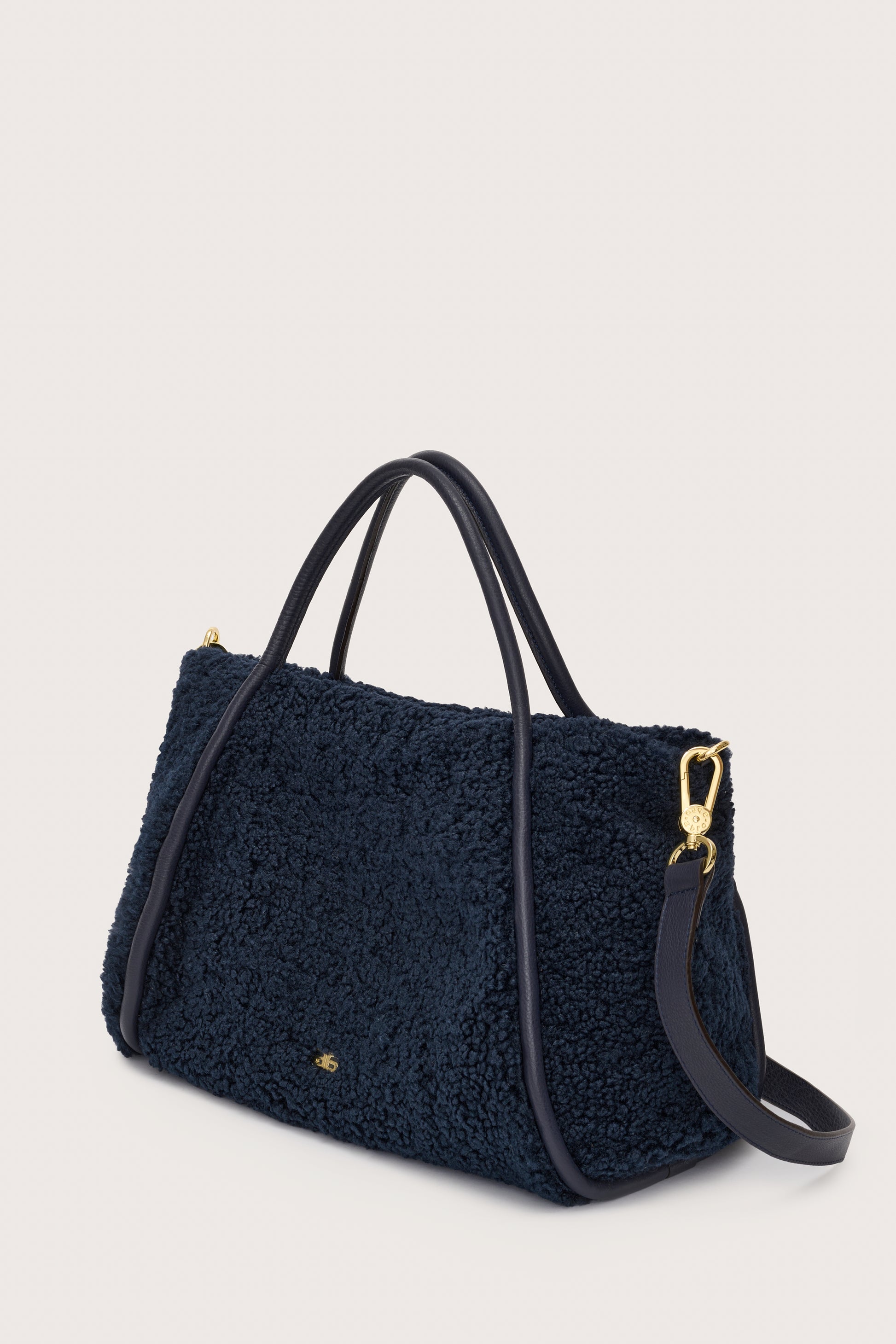 Side view of navy faux shearling bag