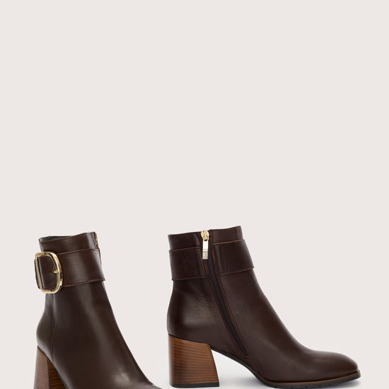 Side view of brown leather boots with gold buckle detail at the ankle