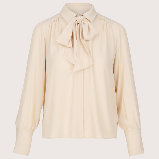 Beige blouse with a bow tie on a light gray background