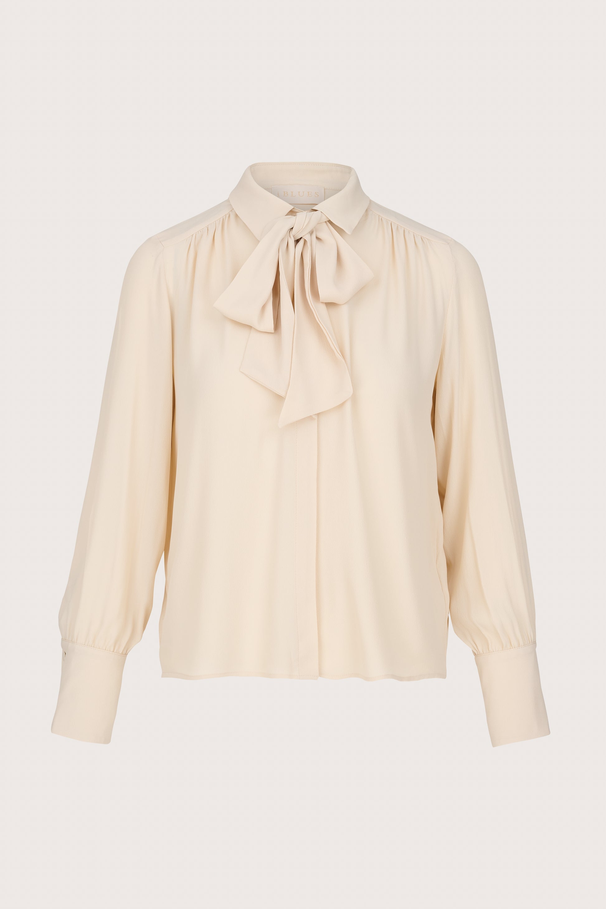 Beige blouse with a bow tie on a light gray background