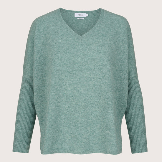 Green cashmere sweater on a light gray background
