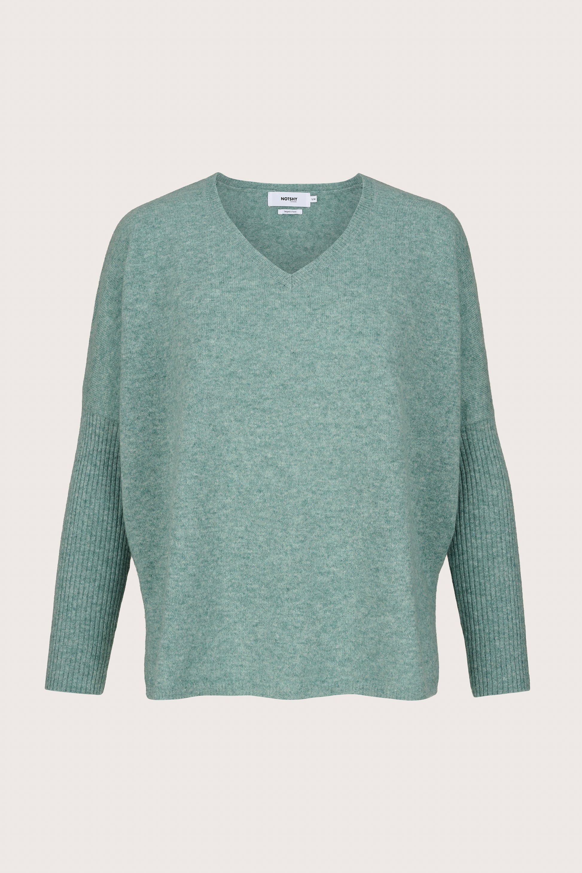 Green cashmere sweater on a light gray background
