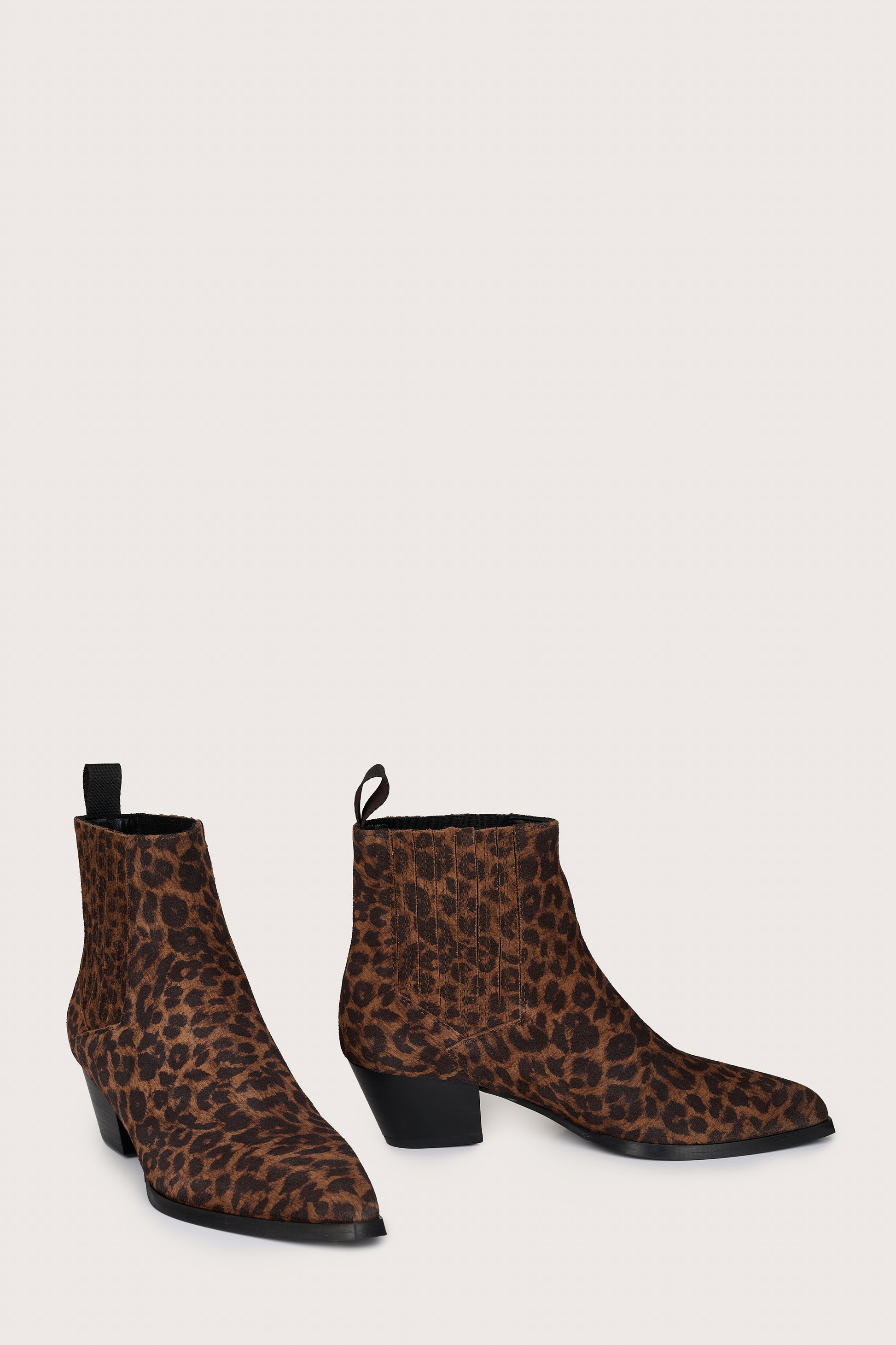 Pair of leopard print ankle boots on a light gray background