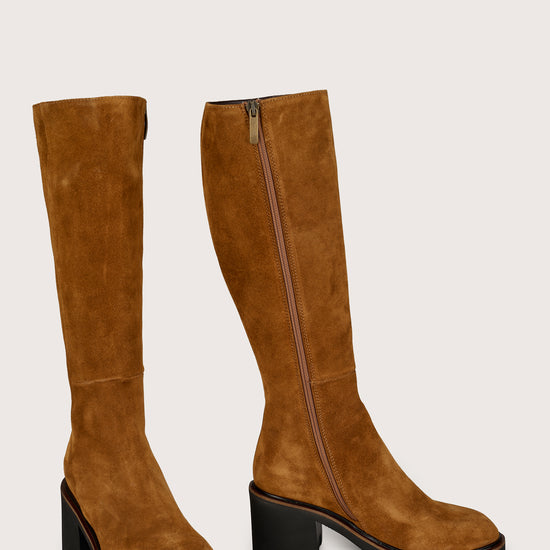 Pair of tan knee-high boots on a light gray background