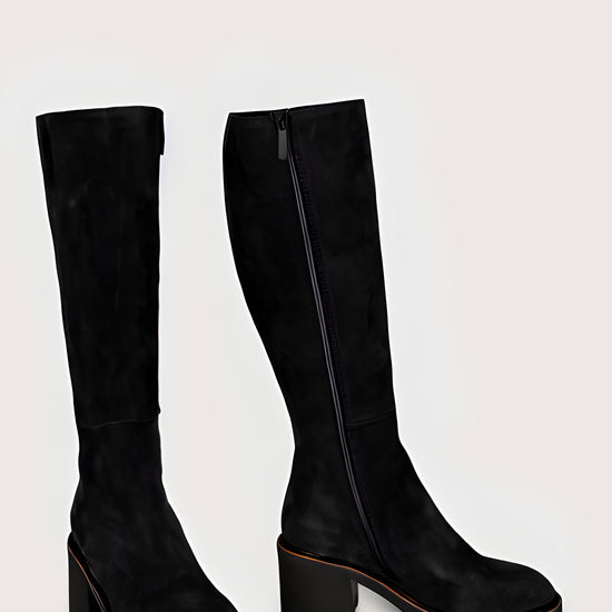 Pair of black knee-high boots on a light gray background