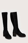 Pair of black knee-high boots on a light gray background