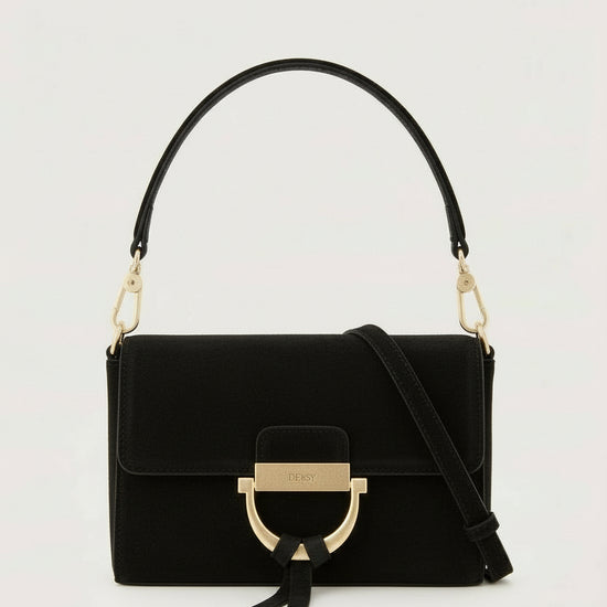 Black handbag with gold accents on a light gray background
