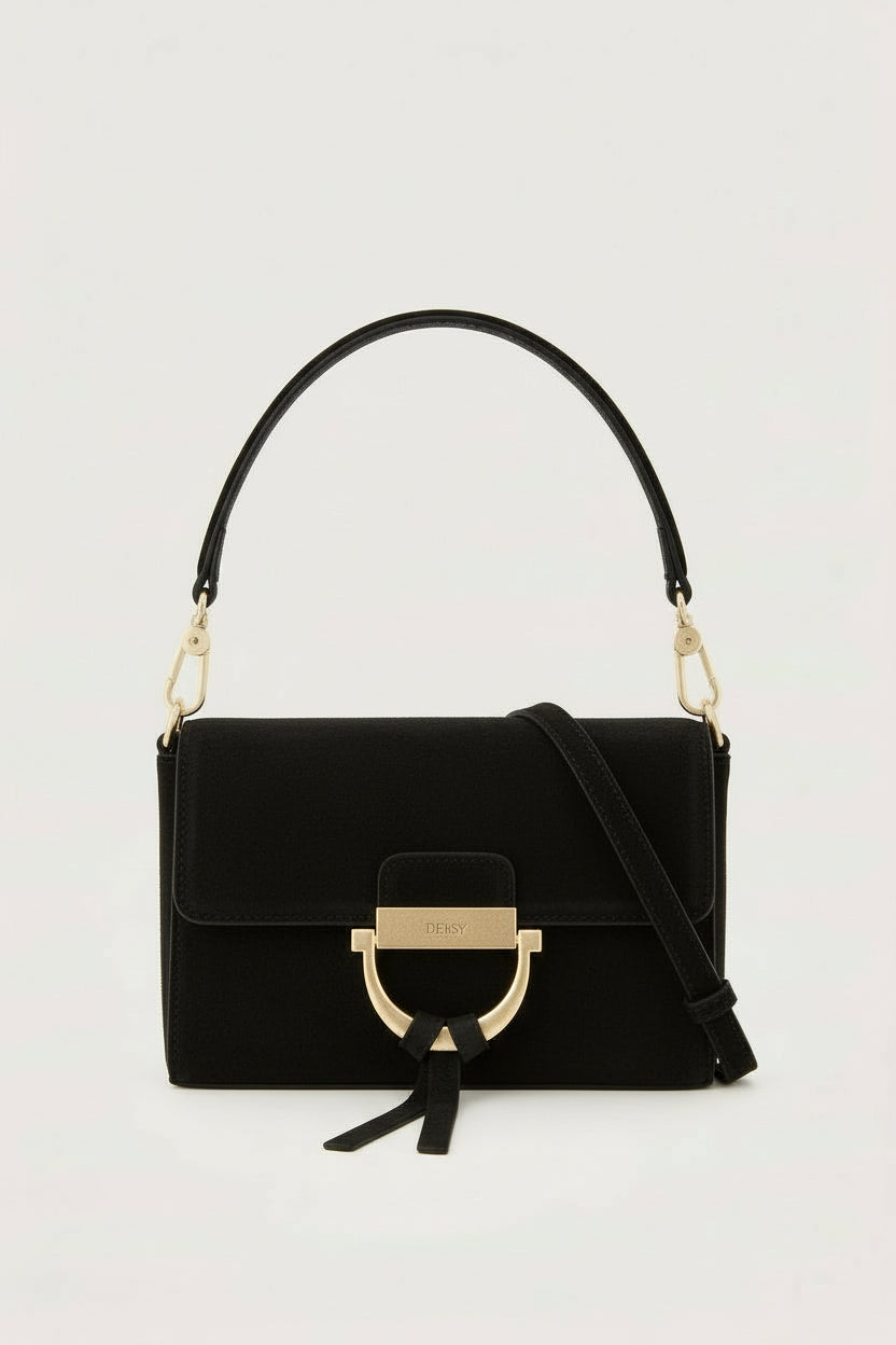 Black handbag with gold accents on a light gray background