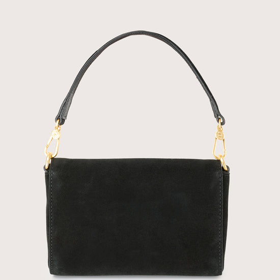 Black handbag with gold chain on a light gray background