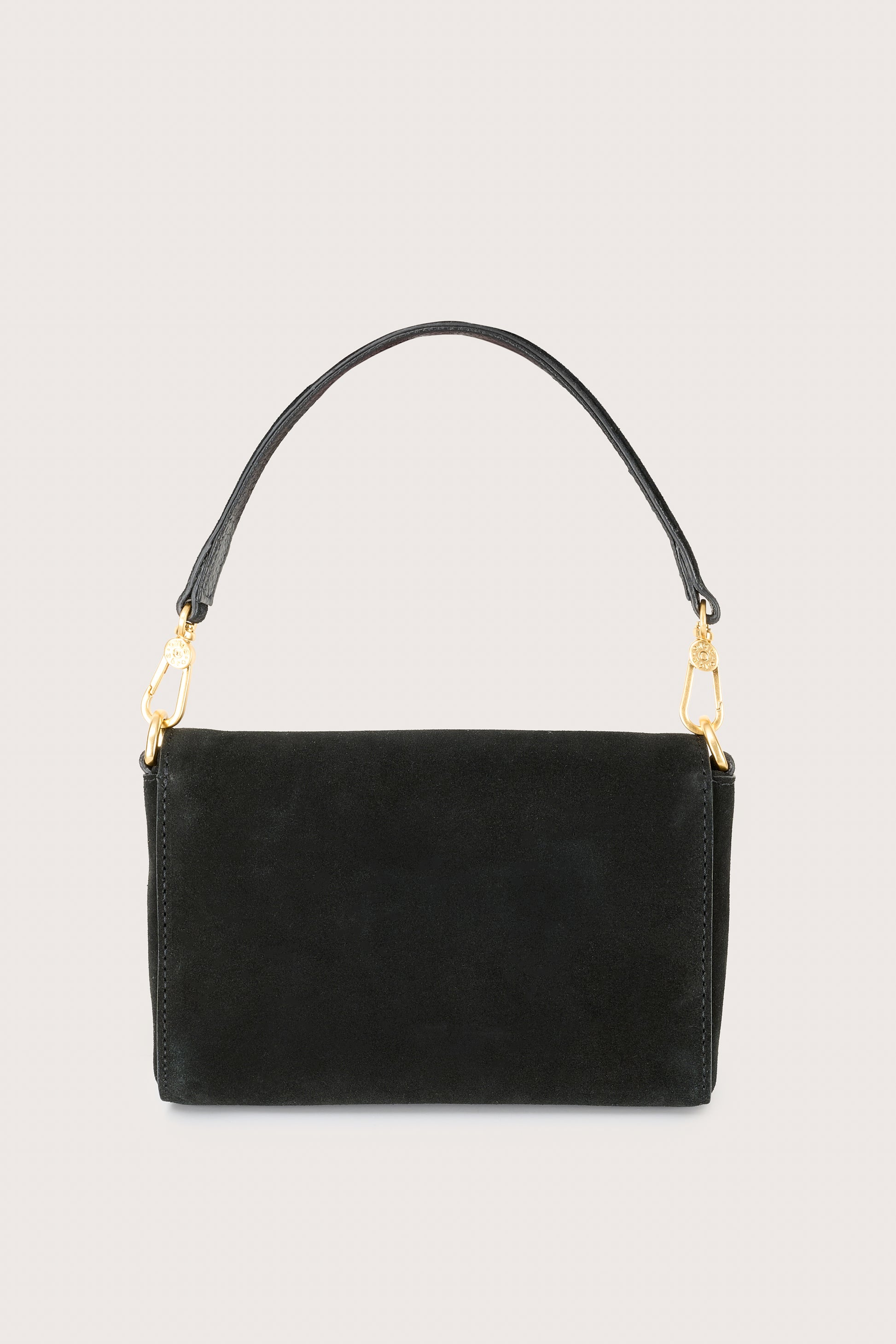 Black handbag with gold chain on a light gray background