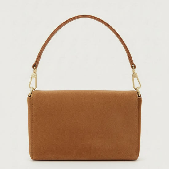 tan suede handbag with a gold clasp on a light gray background