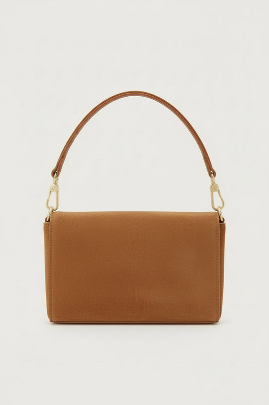 tan suede handbag with a gold clasp on a light gray background