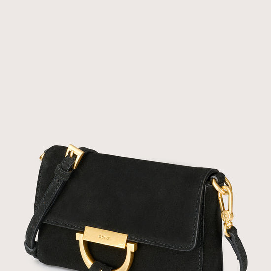 Black handbag with gold accents on a light gray background