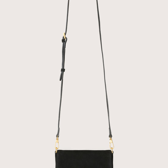 Black handbag with gold accents on a light gray background