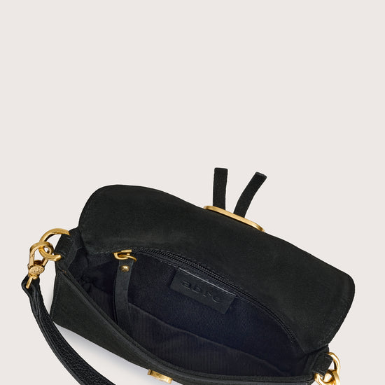 Black handbag with gold accents on a light gray background inside view