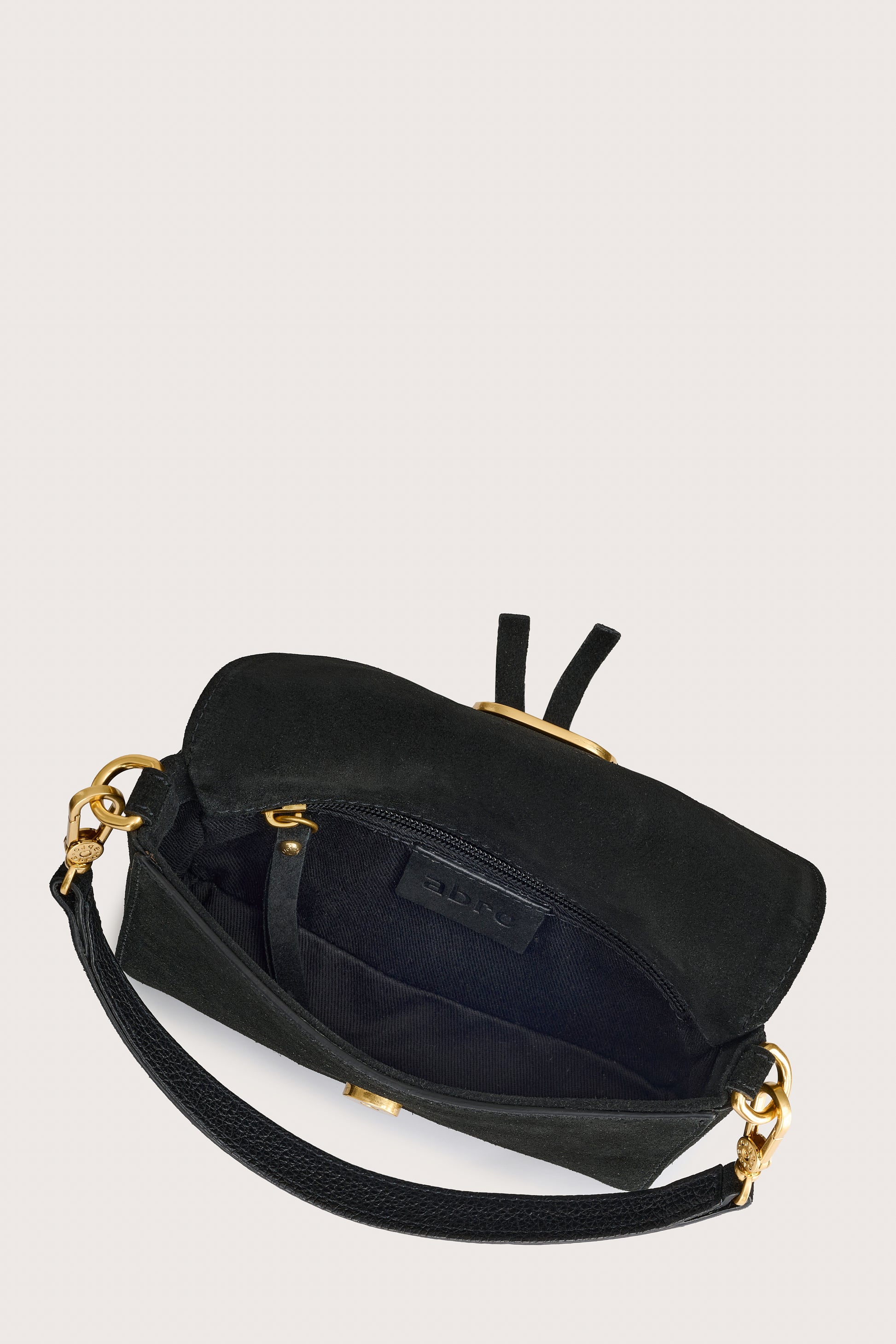 Black handbag with gold accents on a light gray background inside view