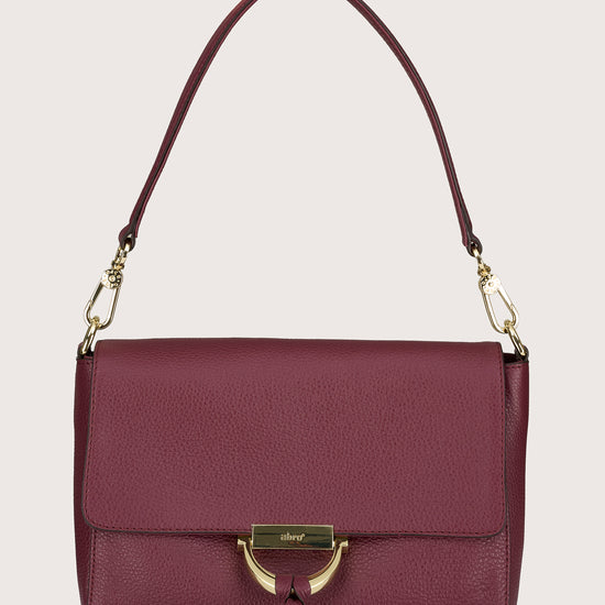 Maroon handbag with gold accents on a beige background