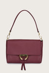 Maroon handbag with gold accents on a beige background