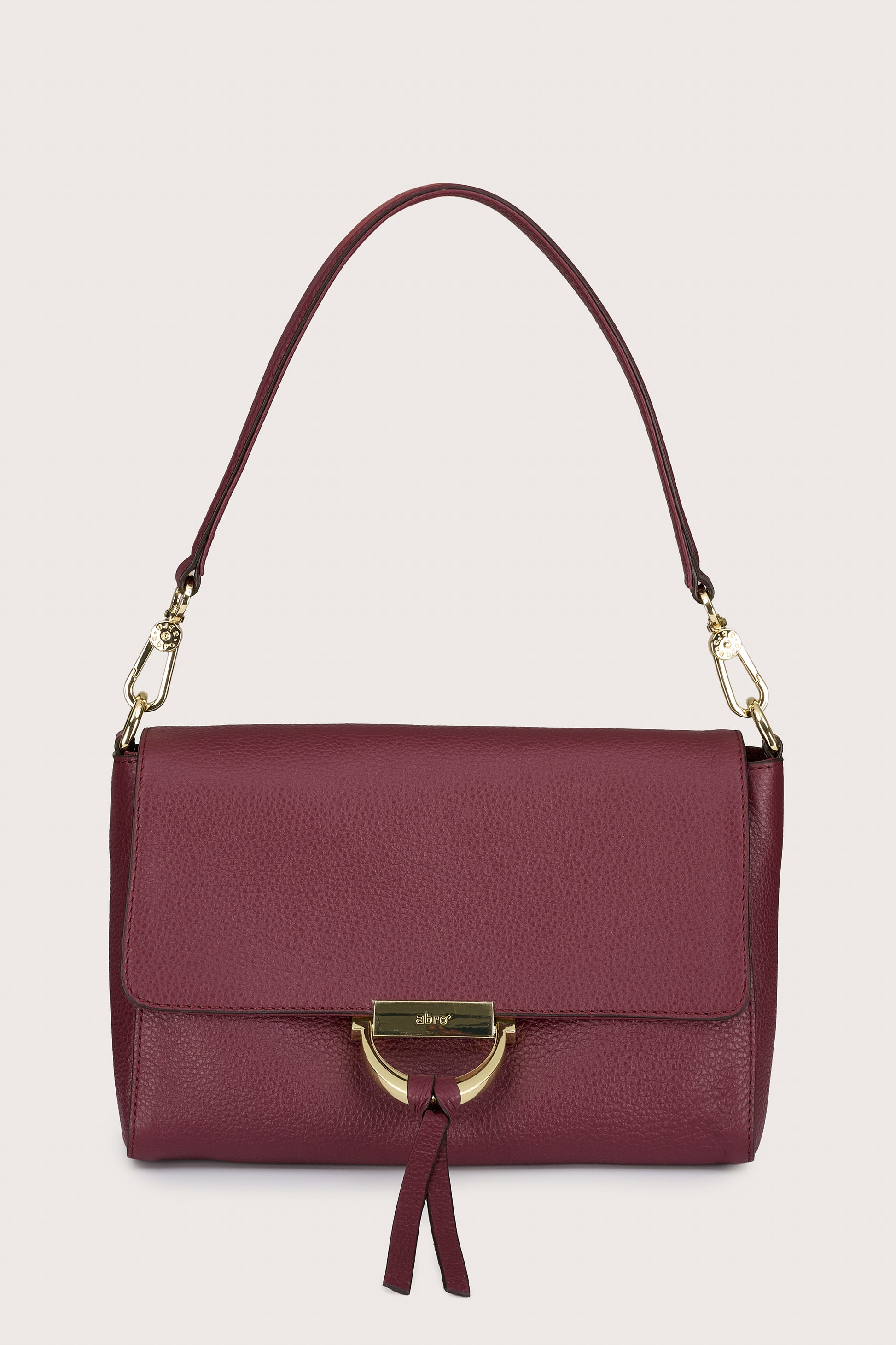 Maroon handbag with gold accents on a beige background