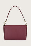 Burgundy handbag with a gold chain strap on a beige background