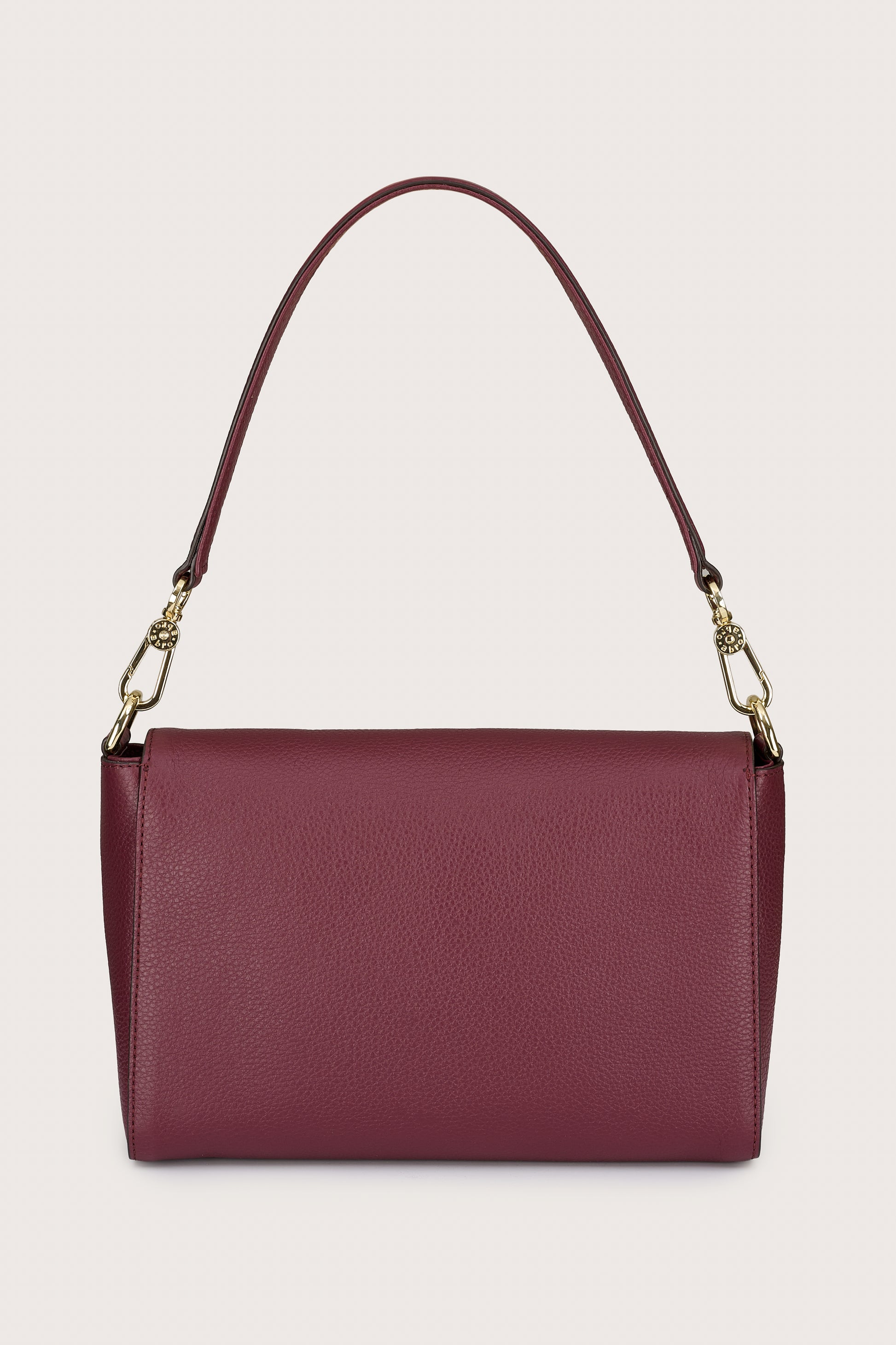 Burgundy handbag with a gold chain strap on a beige background