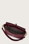 Maroon handbag with gold accents on a light beige background