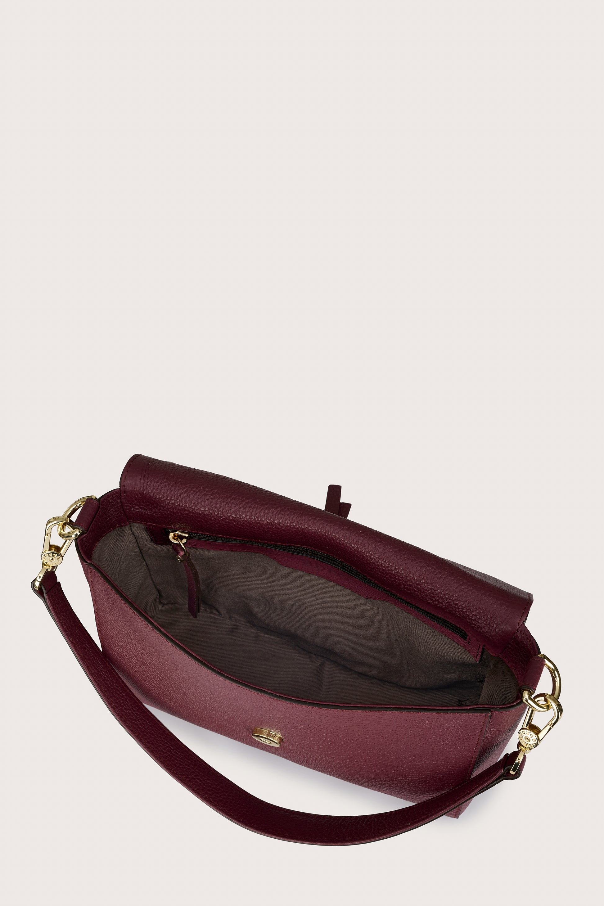 Maroon handbag with gold accents on a light beige background