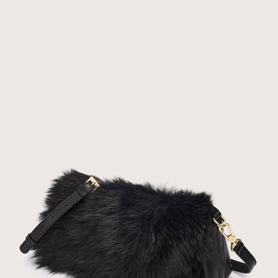 Black fur bag with gold accents on a light gray background