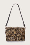 Leopard print handbag with a black strap on a beige background