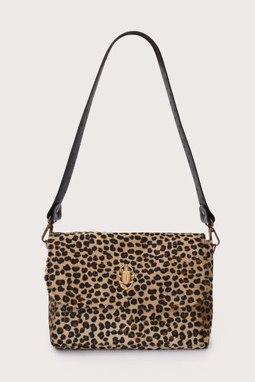 Leopard print handbag with a black strap on a beige background