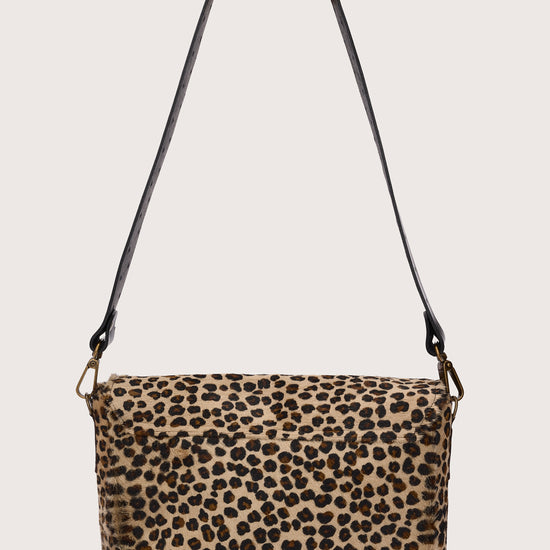 Leopard print handbag with a black strap on a light gray background rear view