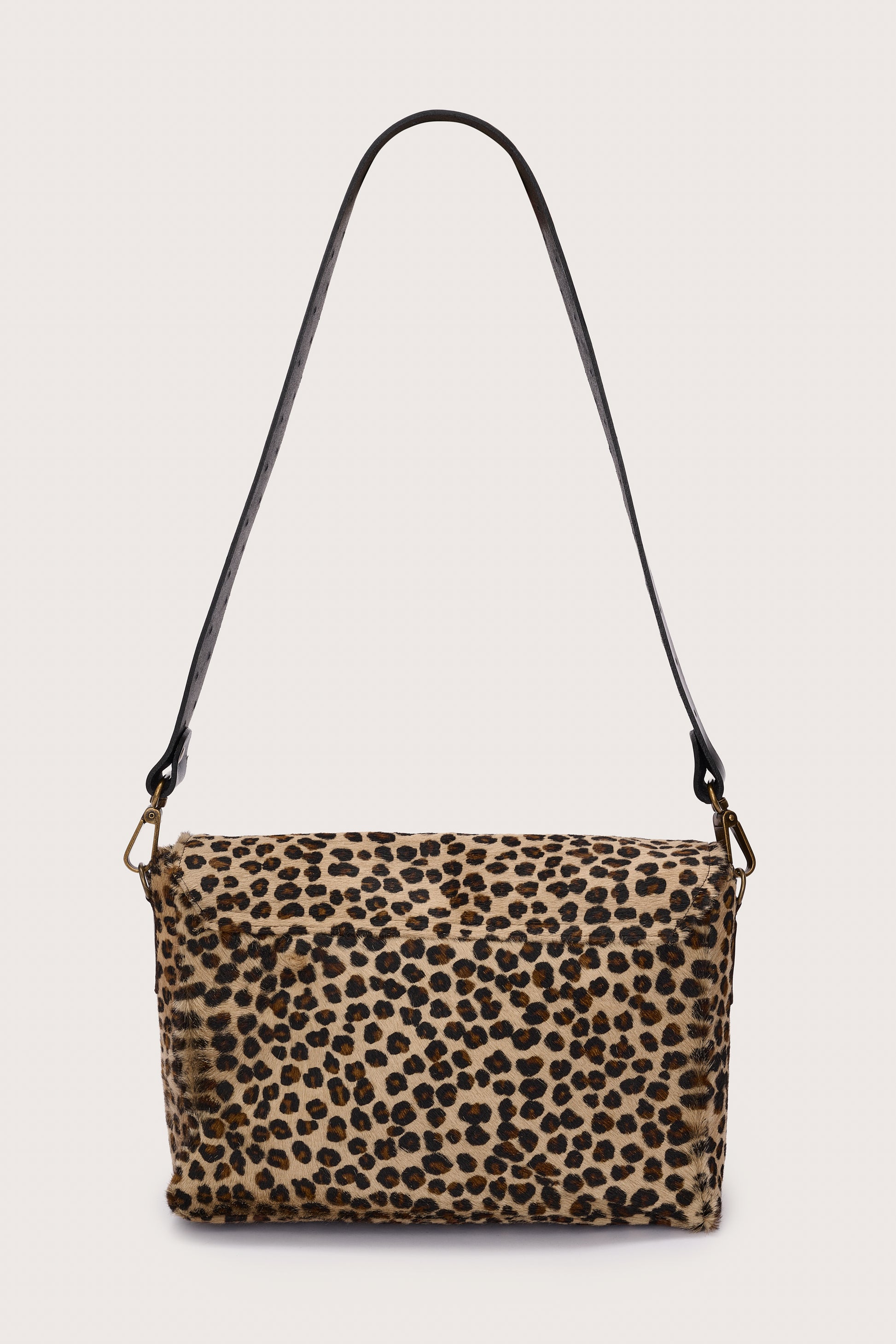 Leopard print handbag with a black strap on a light gray background rear view