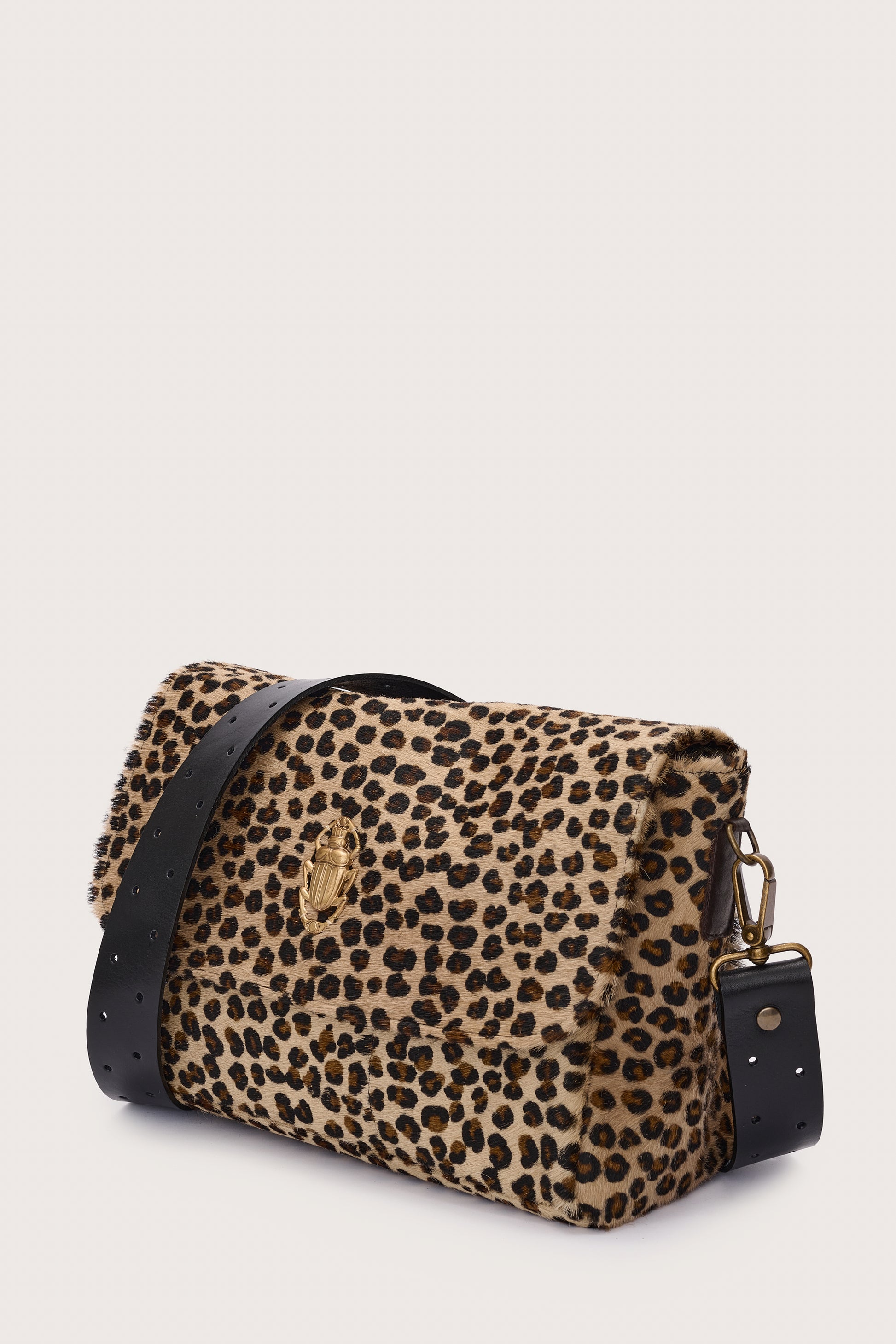 Leopard print handbag with black accents on a light beige background