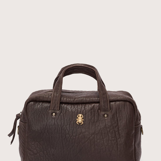 Brown leather bag with a gold clasp on a light gray background
