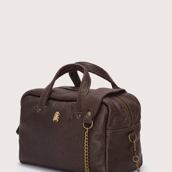 Brown leather bag with a chain detail on a light beige background