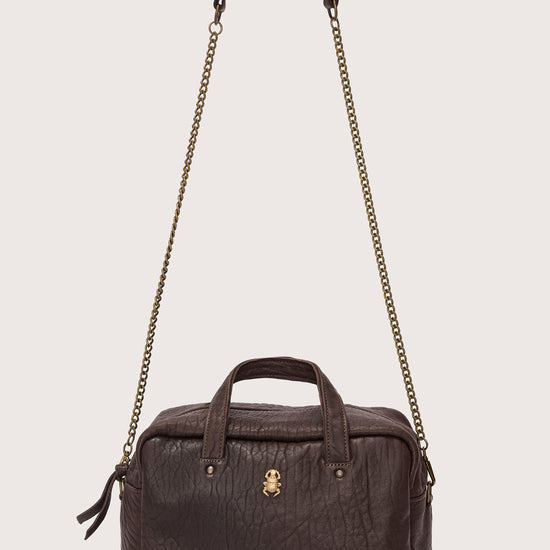 Brown leather handbag with chain strap on a light gray background