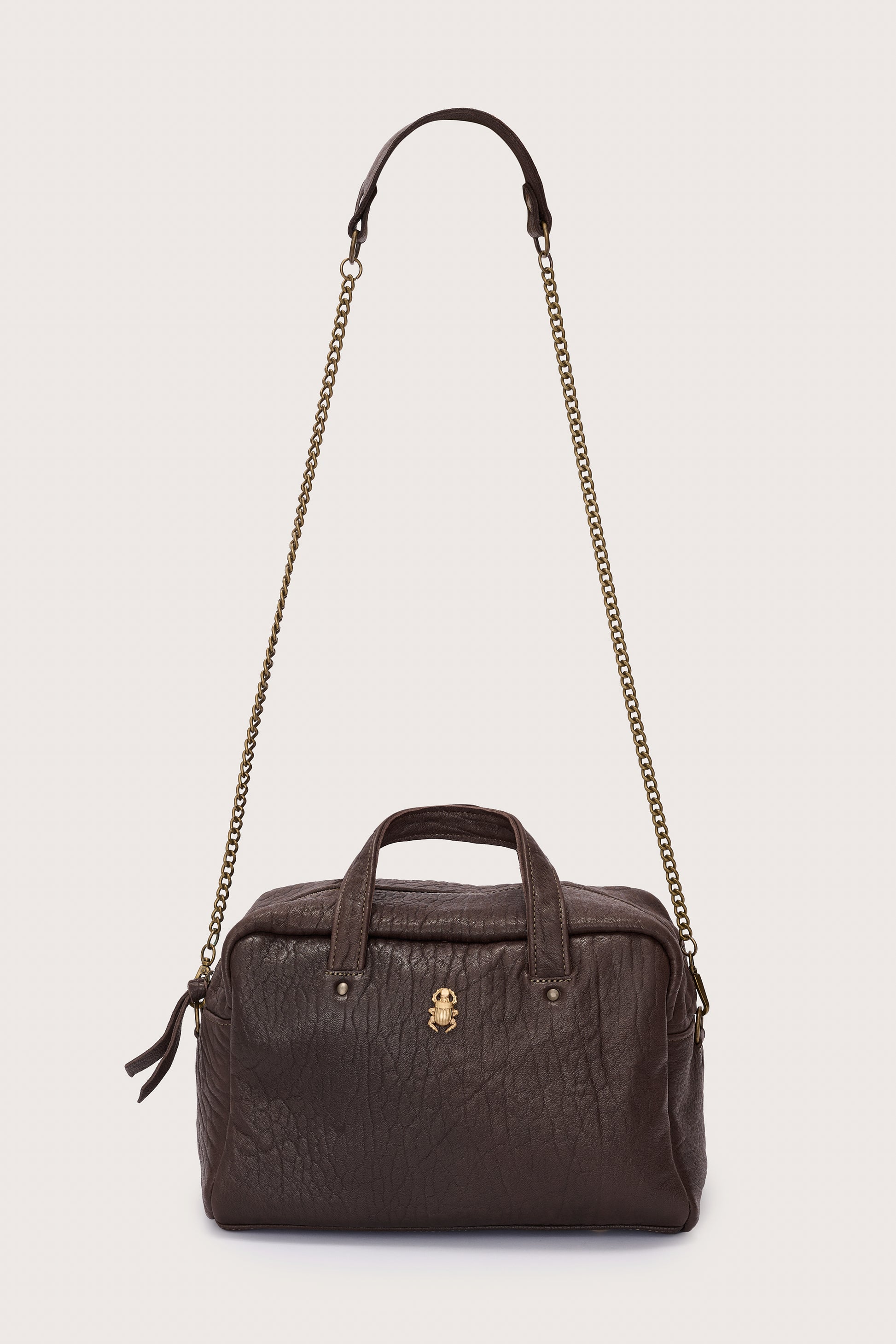 Brown leather handbag with chain strap on a light gray background