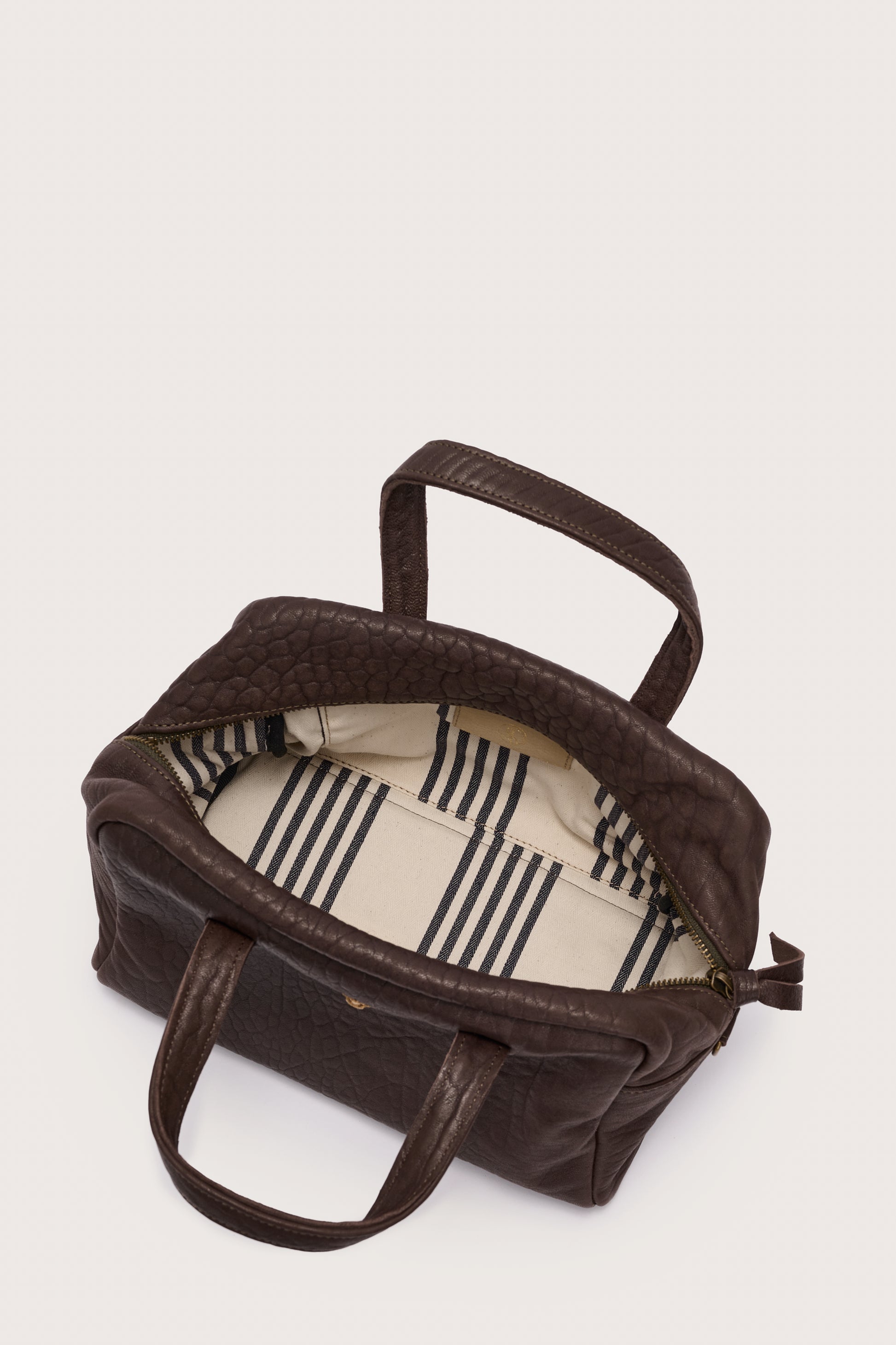 Brown bag with a striped interior on a white background