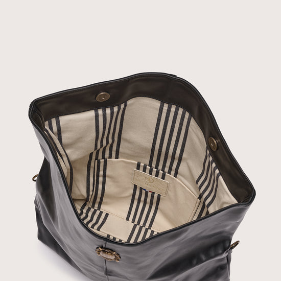 black leather fold over bag with gold scarab stamp and linen strap inside view