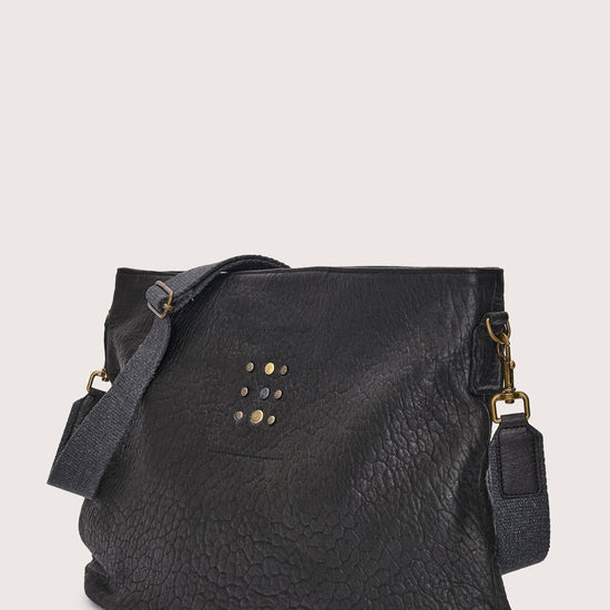 black leather bag with black linen strap and metal stamp detailing side view