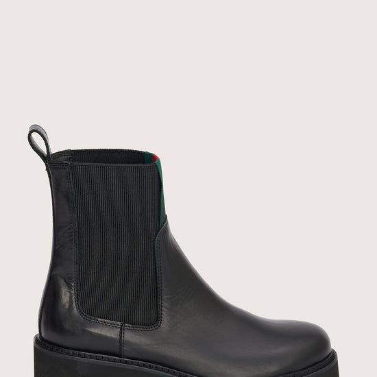 chunky black ankle boots with elasticated panels on side and red/green stripe on the front