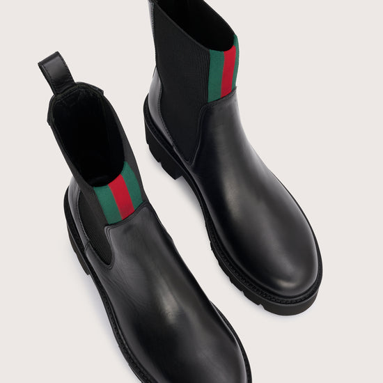 chunky black ankle boots with elasticated panels on side and red/green stripe on the front birds eye view