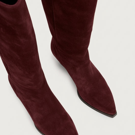 Bordeaux suede knee-high boots on a white background