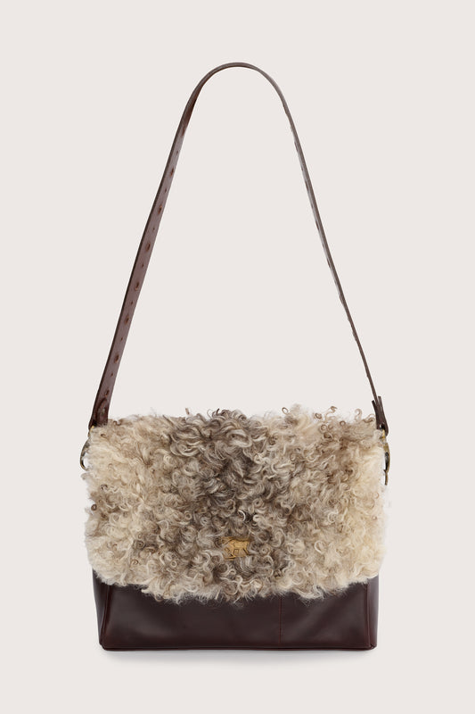 chocolate brown leather cross body bag with short curly hair on the front and a gold panther stamp from sous les paves