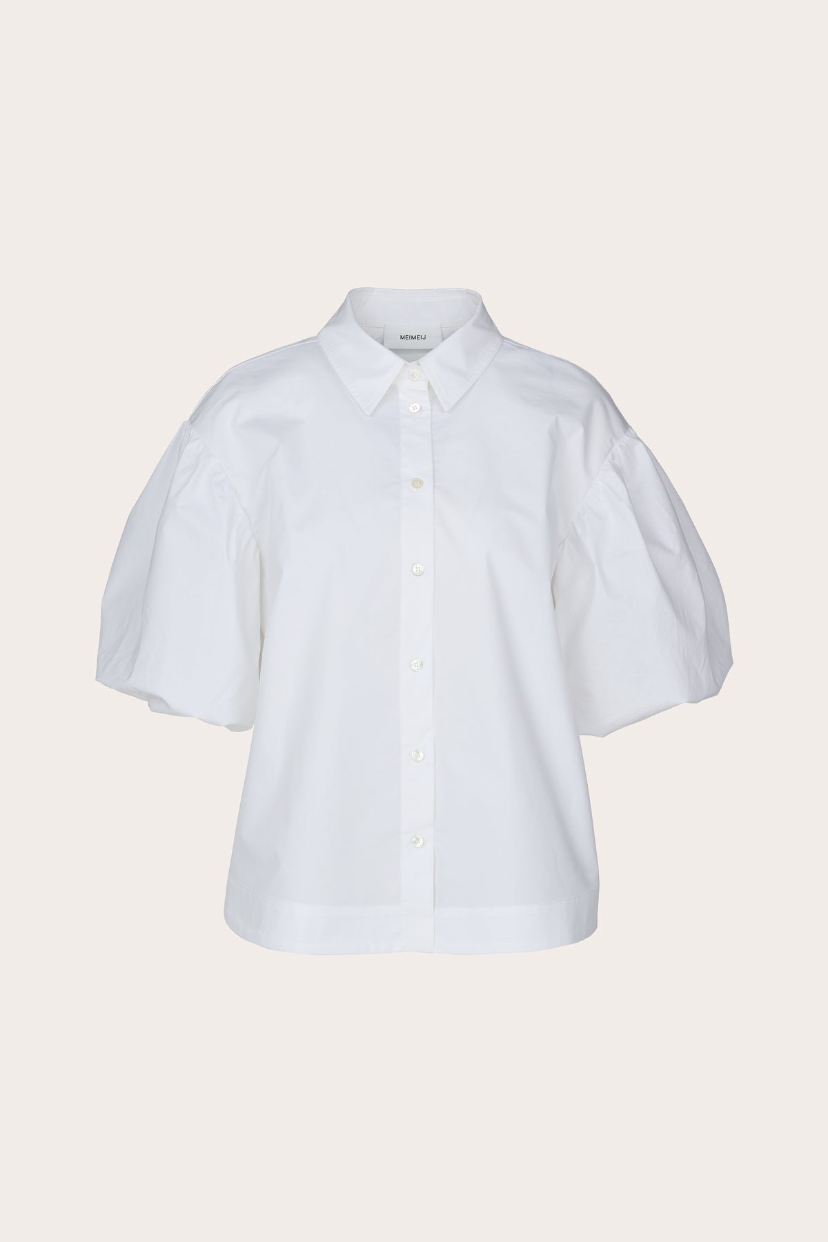 A white short-sleeve button-up shirt with voluminous puff sleeves, a pointed collar, and decorative buttons, shown against a solid light beige background.